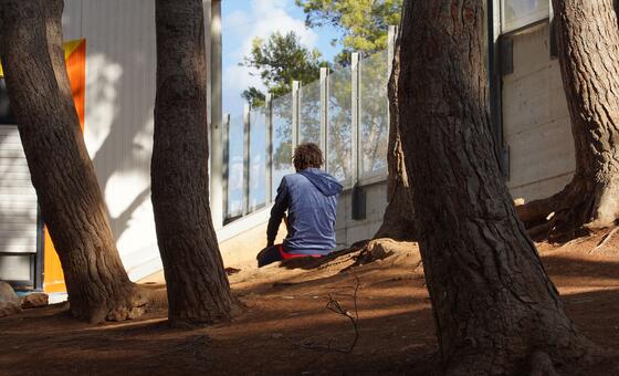 A child sits alone, praying, at a reception centre for migrants in Lampedusa, Italy.